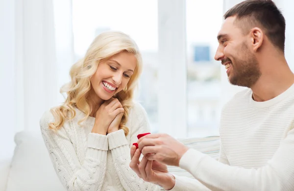 Szczęśliwy człowiek daje pierścionek zaręczynowy na kobiety w domu — Zdjęcie stockowe