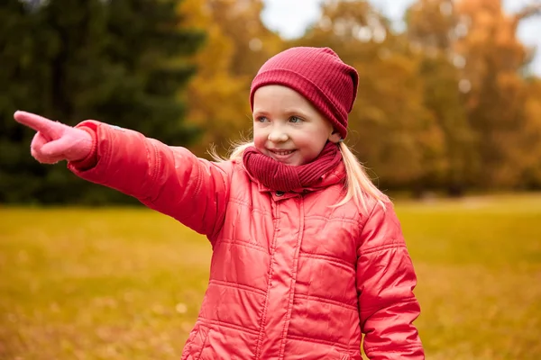 Feliz niña señalando el dedo en otoño parque — Foto de Stock