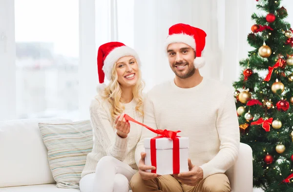 Szczęśliwa para w domu z Boże Narodzenie podatek od darowizn pudło — Zdjęcie stockowe