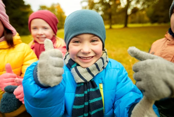 Bambini felici che mostrano i pollici in su nel parco di autunno — Foto Stock