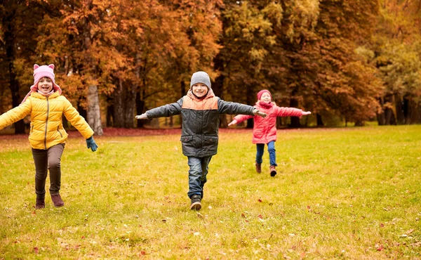 Niños pequeños y felices corriendo y jugando al aire libre —  Fotos de Stock