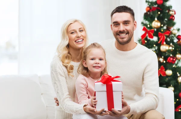 Щаслива сім'я вдома з різдвяною подарунковою коробкою — стокове фото