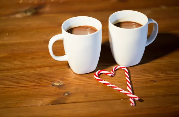 크리스마스 사탕 지팡이 및 나무 테이블에 컵 — 스톡 사진
