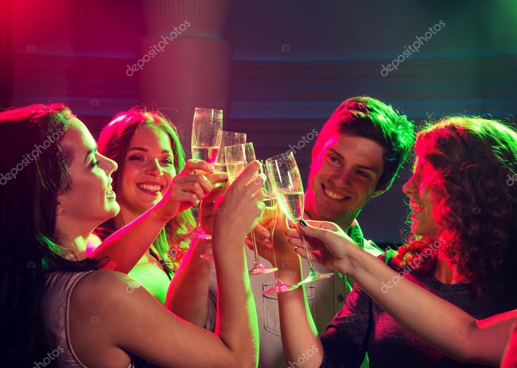 party, technology, nightlife and people concept - smiling friends with  smartphone taking selfie in club. Stock Photo