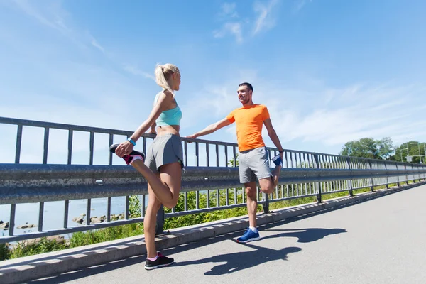 Smiling couple stretching outdoors — Stock Photo, Image