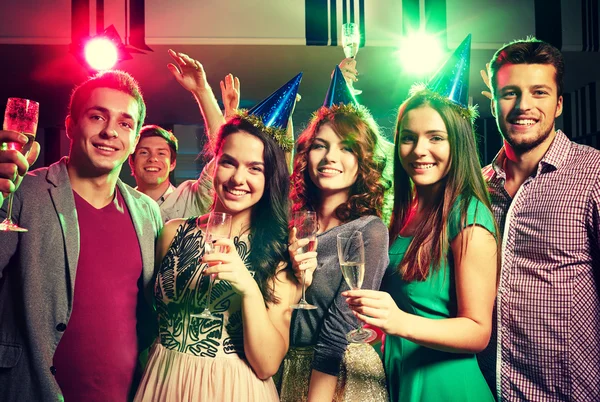 Smiling friends with glasses of champagne in club — Stock Photo, Image