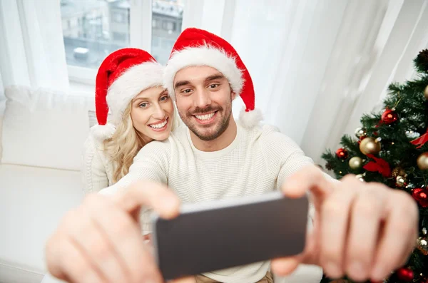 Пара делает селфи со смартфоном на Рождество — стоковое фото
