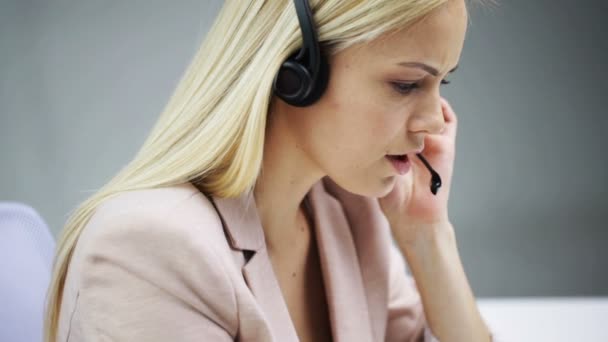 Mujer de negocios con auriculares hablando en la oficina — Vídeo de stock