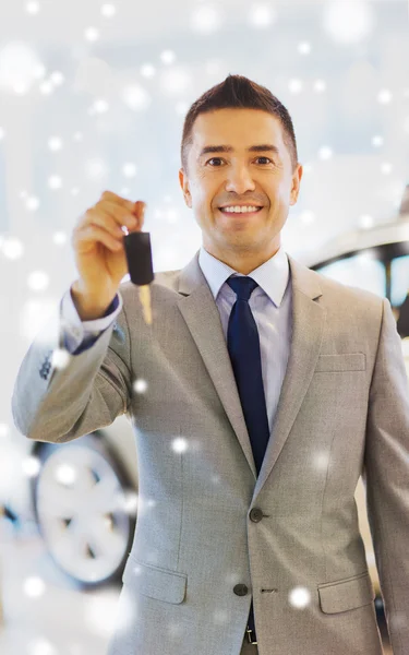 Homme heureux montrant la clé au salon de l'auto ou de la voiture — Photo