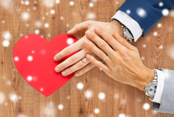 Close up of male gay couple hands with red heart — Stock Photo, Image