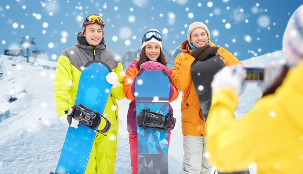 Happy přátelé se snowboardy a smartphone — Stock fotografie