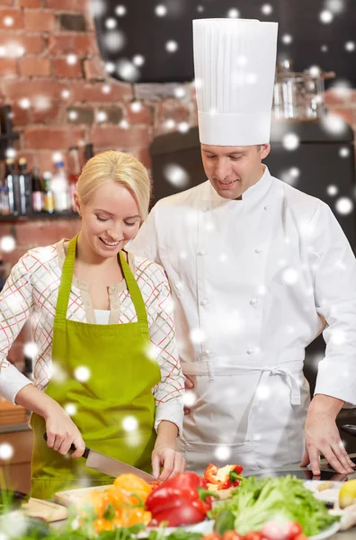 キッチンで料理をする女性と幸せな男性シェフ料理 — ストック写真
