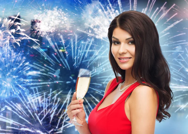 Hermosa mujer con copa de champán sobre fuegos artificiales — Foto de Stock