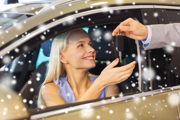Mulher feliz recebendo chave do carro em auto show ou salão Imagens De Bancos De Imagens