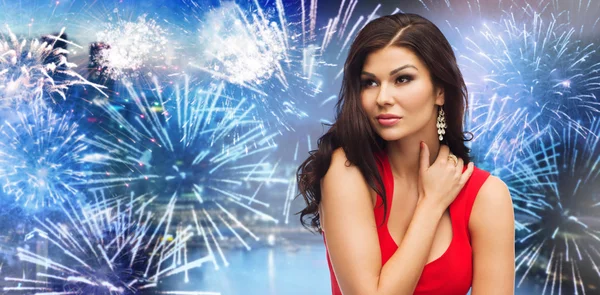 Beautiful woman in red over firework at night city Stockfoto