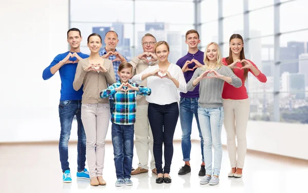 Grupo de personas sonrientes mostrando el signo de la mano del corazón —  Fotos de Stock