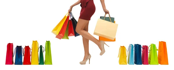 Close up of woman on high heels with shopping bags — Stock Photo, Image