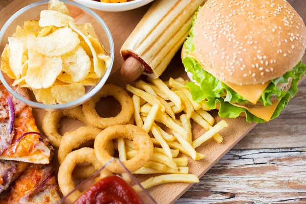 Närbild på snabbmat snacks på träbord — Stockfoto