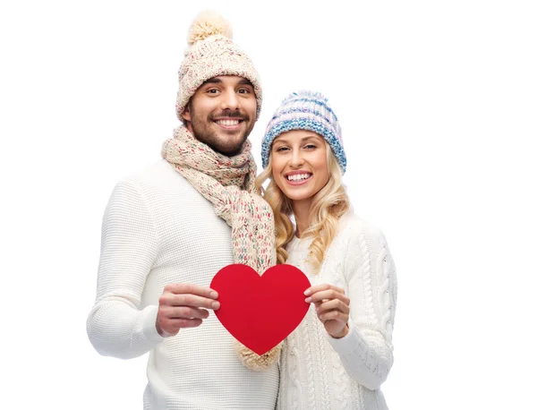 Lächelndes Paar in Winterkleidung mit rotem Herz — Stockfoto