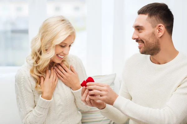 Felice uomo dando anello di fidanzamento alla donna a casa — Foto Stock