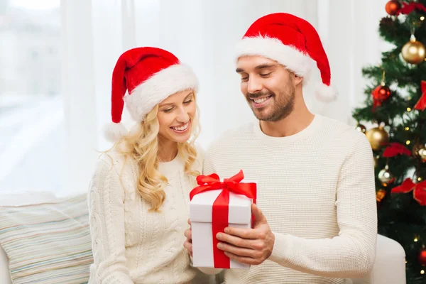 Feliz pareja en casa con caja de regalo de Navidad —  Fotos de Stock