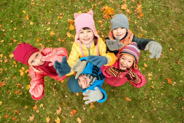 Happy children waving hands in autumn park — Stock Photo, Image