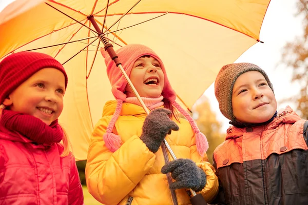 Счастливые дети с зонтиками в осеннем парке — стоковое фото