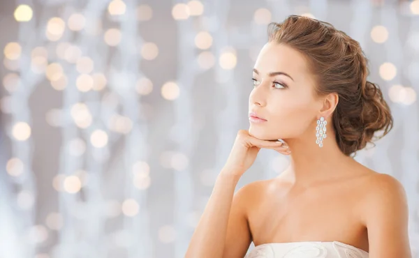 Beautiful woman wearing shiny diamond earrings Royalty Free Stock Images
