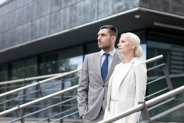 Serious businessmen standing over office building — Stock Photo, Image
