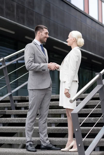 Smiling businessmen shaking hands on street — Stock Photo, Image