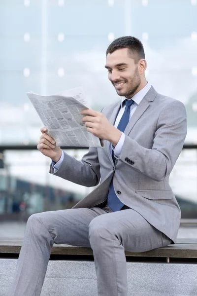 Giovane uomo d'affari sorridente giornale all'aperto — Foto Stock