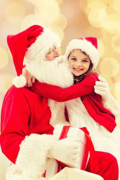 Lachende meisje met santa claus — Stockfoto