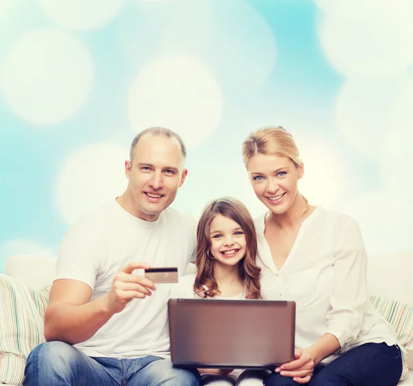 Familia feliz con ordenador portátil y tarjeta de crédito —  Fotos de Stock