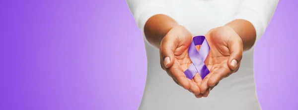 Close up of hands holding purple awareness ribbon — Zdjęcie stockowe