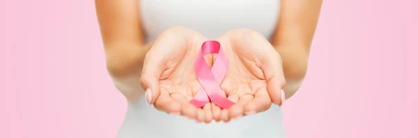 Hands holding pink breast cancer awareness ribbon — Stock Photo, Image