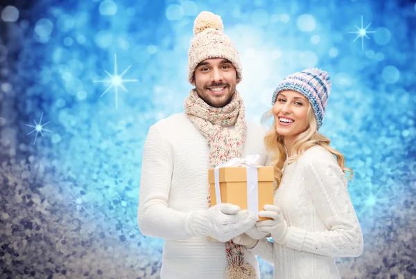 Casal sorridente em roupas de inverno com caixa de presente — Fotografia de Stock