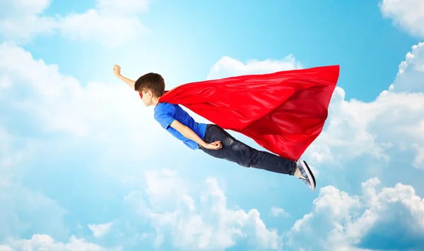 男孩穿红色超人披风和面具在空中飞 — 图库照片