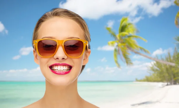 Mujer joven feliz en gafas de sol con lápiz labial rosa — Foto de Stock