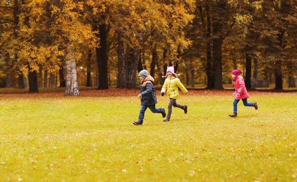 Группа счастливых маленьких детей, бегущих на открытом воздухе — стоковое фото