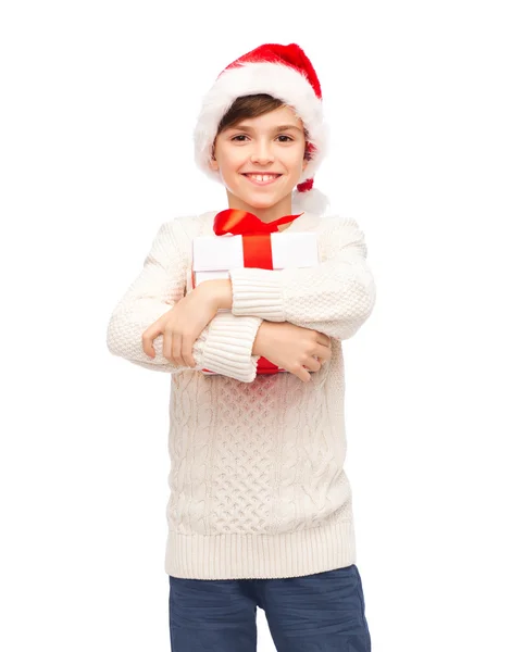 Sourire garçon heureux dans le chapeau de Père Noël avec boîte cadeau — Photo