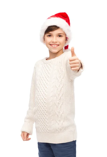 Smiling happy boy in santa hat showing thumbs up — Stock Photo, Image