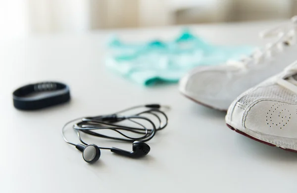 Close up of earphones, bracelet and sportswear — Stock Photo, Image