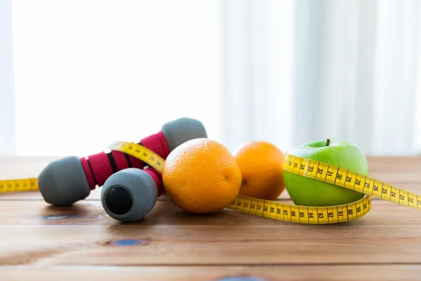 Primer plano de la mancuerna, frutas y cinta métrica — Foto de Stock