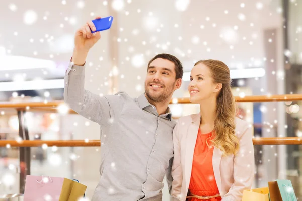 Feliz pareja con smartphone tomando selfie en el centro comercial —  Fotos de Stock