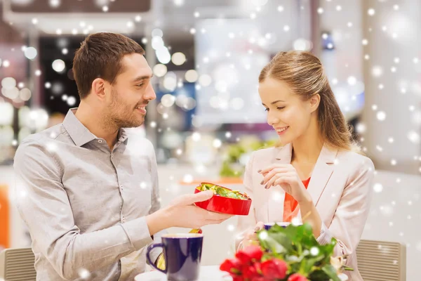 Happy couple with chocolate box and roses in mall — ストック写真