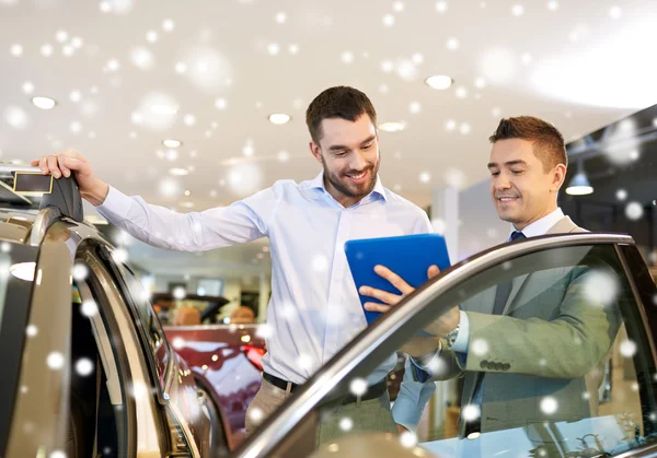 Šťastný muž s prodejci aut v autosalonu nebo salónek — Stock fotografie