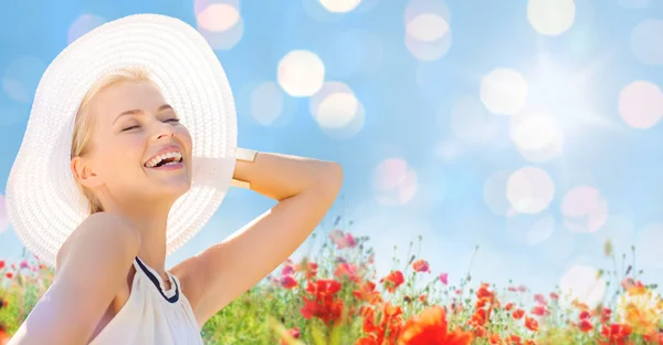 Sonriente joven en sombrero de paja en el campo de amapola — Foto de Stock