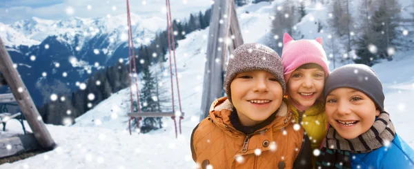 Happy children hugging over winter background — Stockfoto