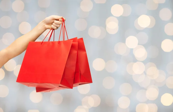 Close up of hand holding red shopping bags — Zdjęcie stockowe