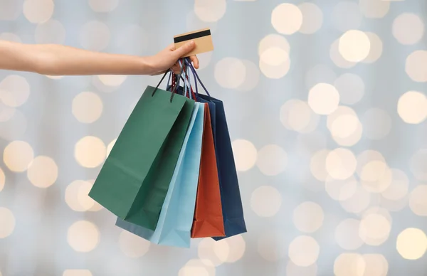 Close up of woman with shopping bags and bank card — Stockfoto